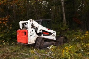 A bulldozer parked in a forest clearing surrounded by autumn foliage in Harbor Springs, Michigan.
